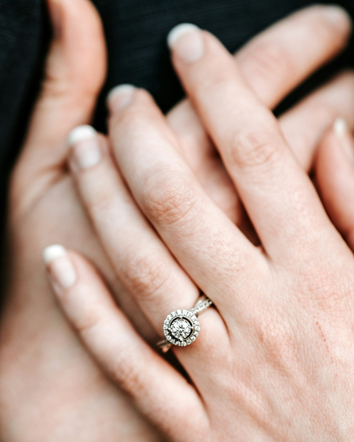 Couple holding hands, one wearing a diamond ring