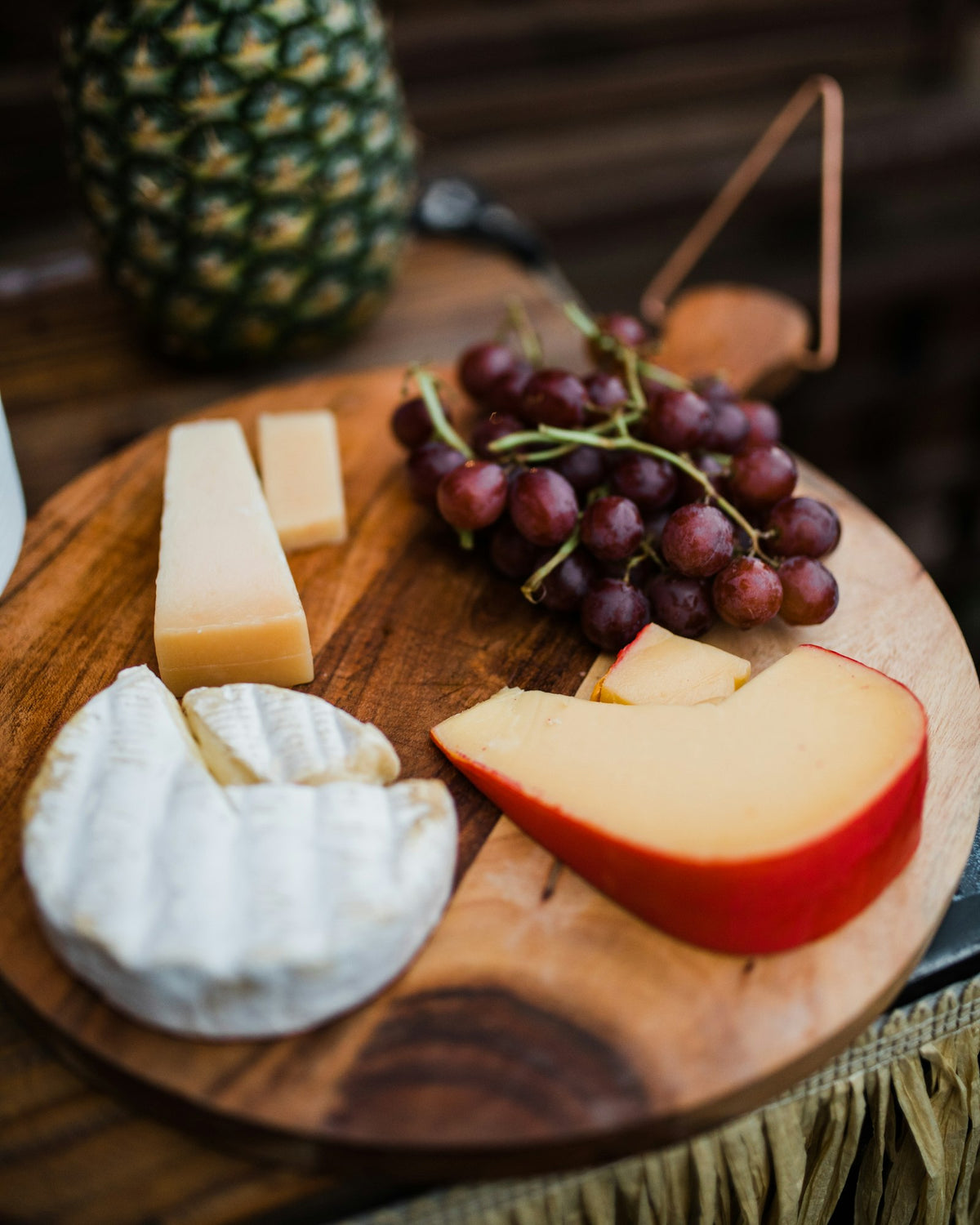 Cheese board with brie, aged cheese and grapes