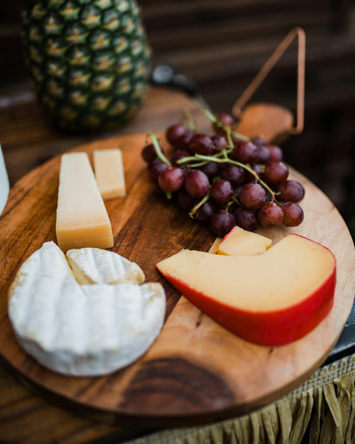 Cheese board with brie, aged cheese and grapes