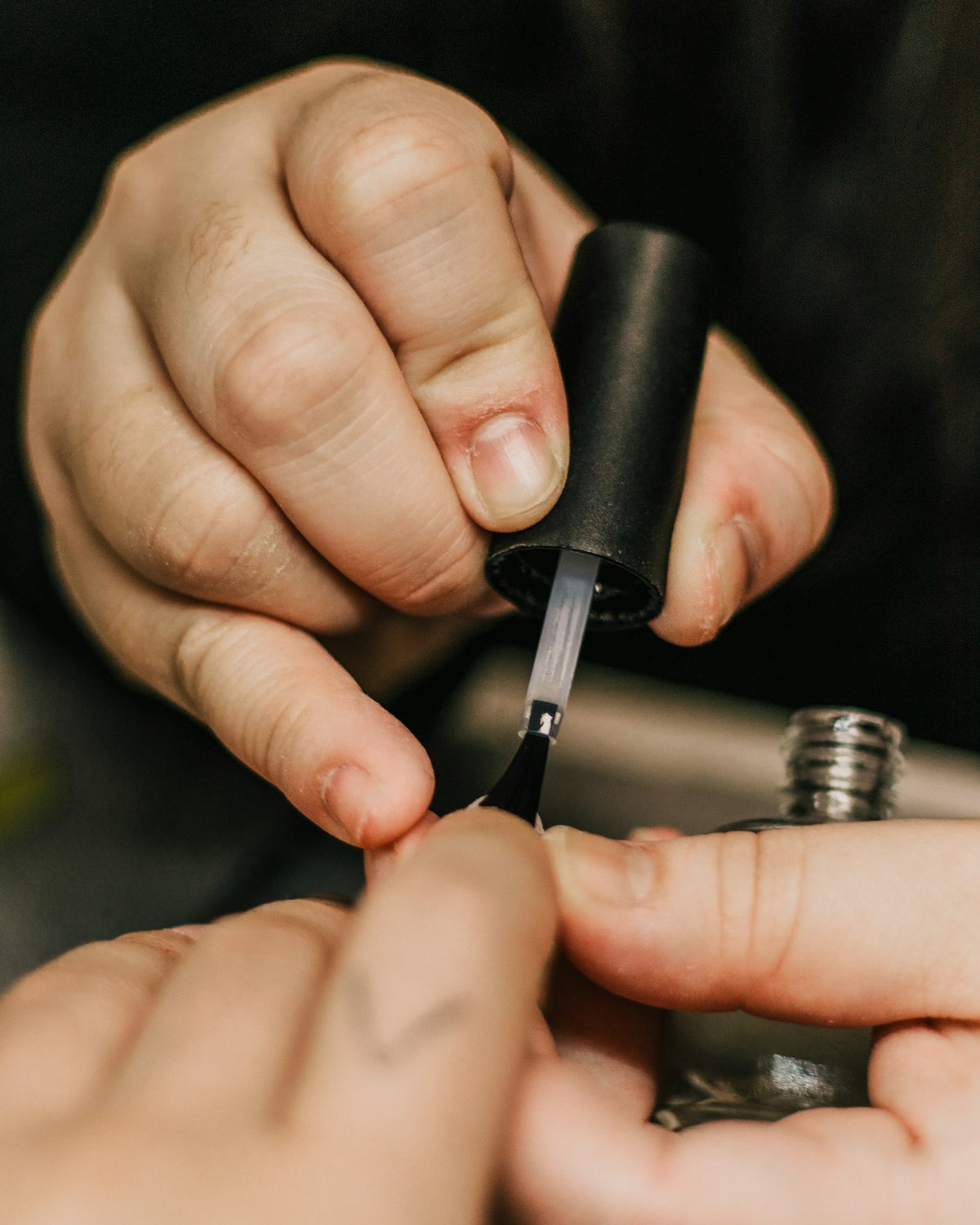 Manicurist applying nail polish