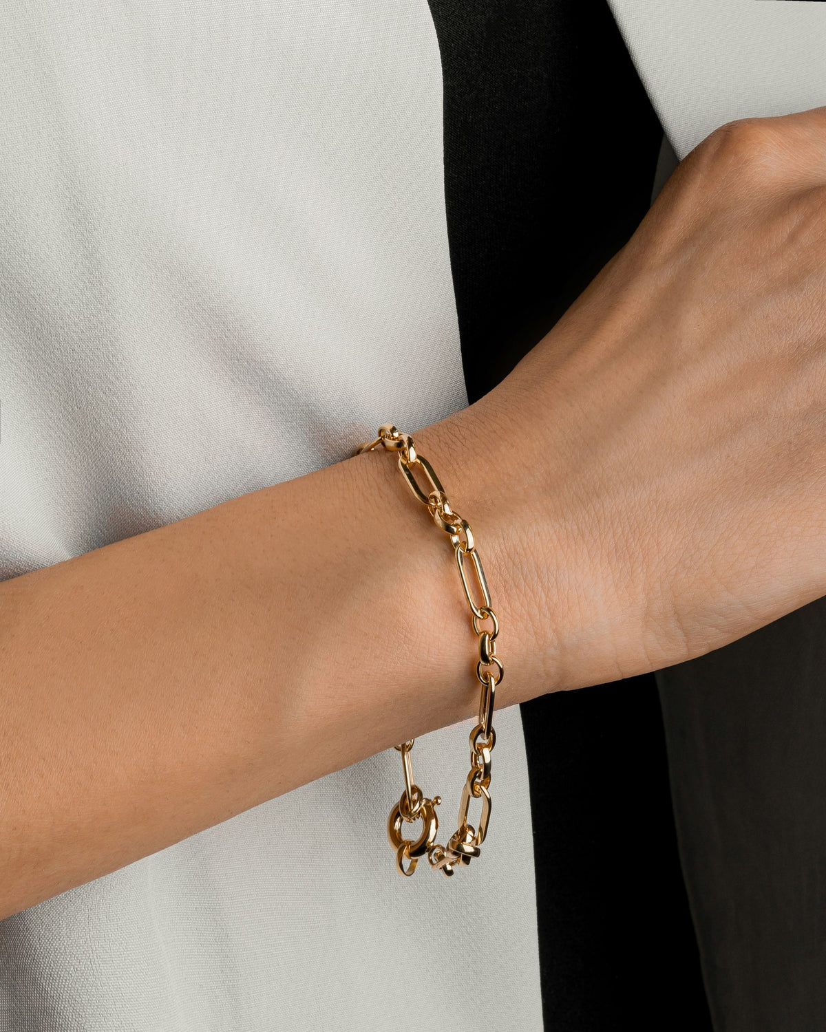 A gold link chain bracelet on a wrist