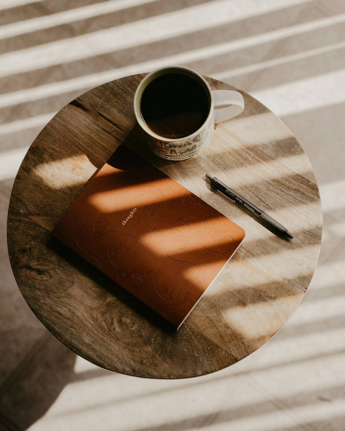 Leather notebook and pen on a sunlit table