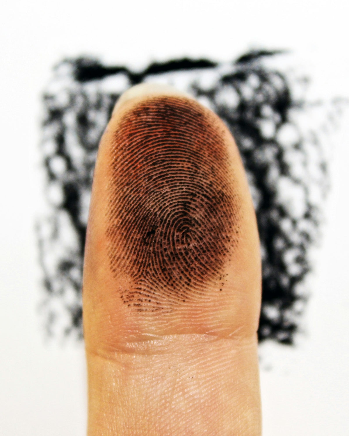An inked fingertip ready for fingerprinting