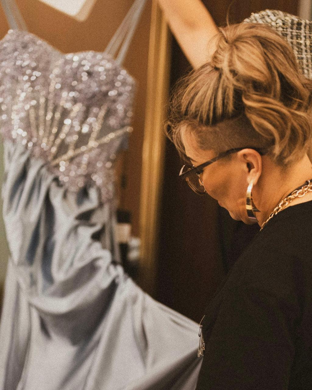 Seamstress checking a beaded evening gown