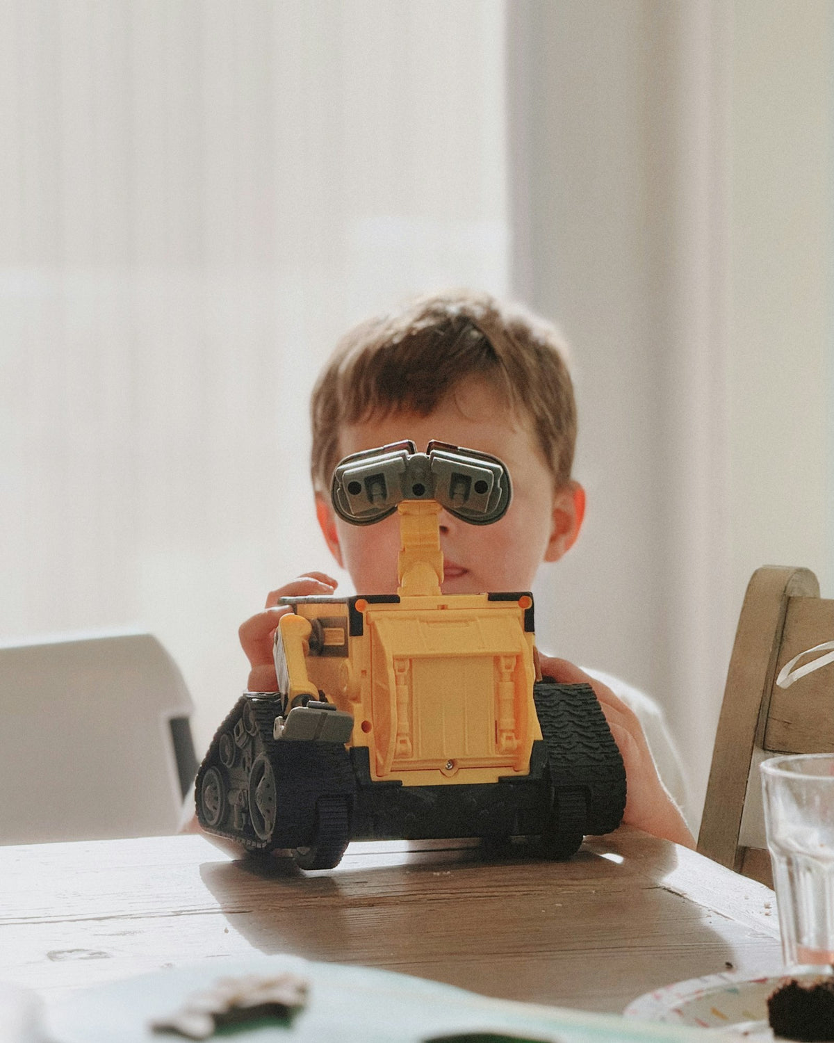 Child building a small robot at a table