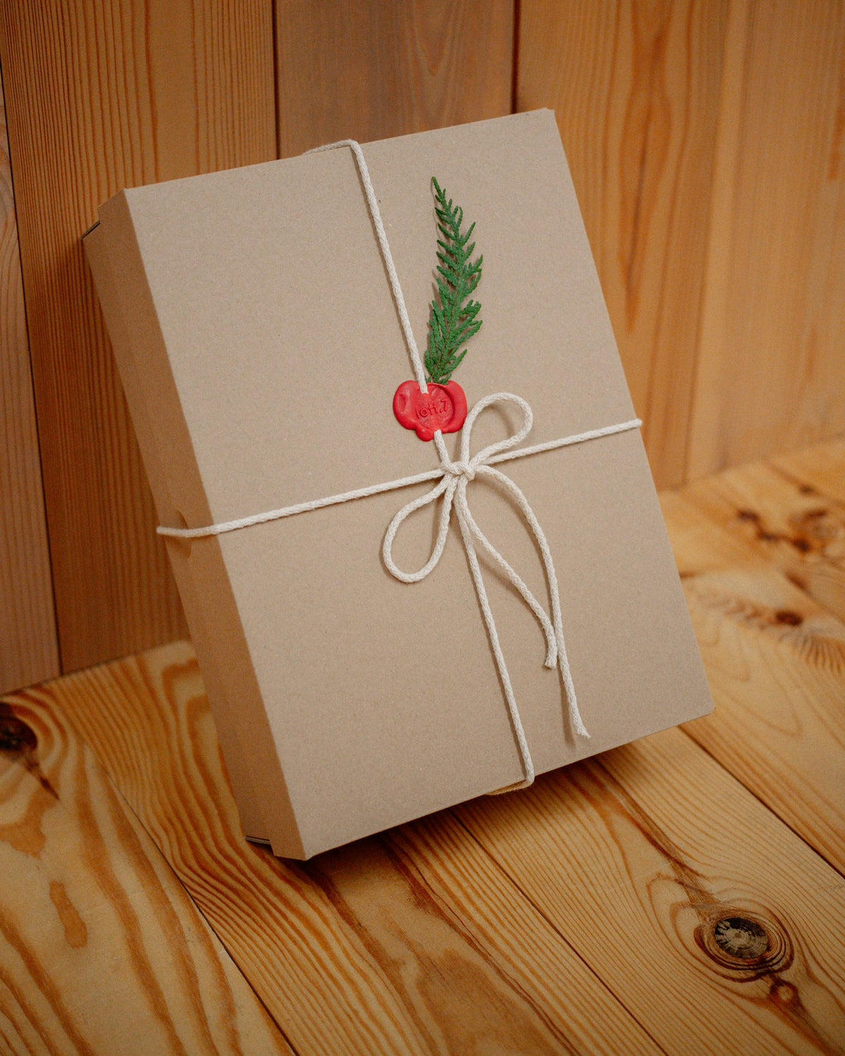 A kraft gift box tied with twine on warm wood